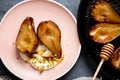 Baked pears with honey, cheese cream and pistachio in a pink dish