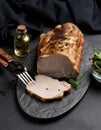 Baked piece of pork balyk on the table with spices. Tenderloin cut into pieces