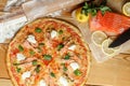 Baked pizza with salmon and feta and ingredients. Italian traditional food Royalty Free Stock Photo