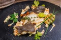 Baked plaice fillet with vegetables and sauce close-up on a bla Royalty Free Stock Photo