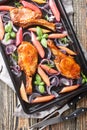 Baked pork chops with caramelized onions and rhubarb close-up in a baking sheet. Vertical top view Royalty Free Stock Photo