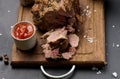 Baked pork collar with spices on a wooden board, delicious and juicy meat