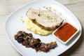 Baked pork with mashed potatoes, fried mushrooms and tomato sauce.