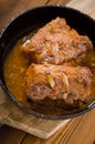 Baked pork ribs in a frying pan. Wooden rustic background. Top view. Selective focus Royalty Free Stock Photo