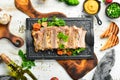 Baked pork ribs with mustard and spices on a black stone plate. Top view. Royalty Free Stock Photo