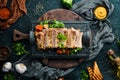 Baked pork ribs with mustard and spices on a black stone plate. Top view. Royalty Free Stock Photo