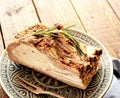 Baked pork ribs, rosemary on a plate, napkin and fork on a wooden background