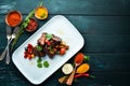 Baked pork ribs with vegetables. In the plate. Royalty Free Stock Photo