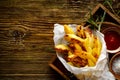 Baked potato fries, wedges with addition sea salt and rosemary on a wooden background, top view. Royalty Free Stock Photo