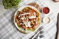 Baked potato with greens, garlic and sauces on a white plate Royalty Free Stock Photo