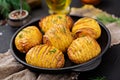 Baked potato with herbs on black background. Vegan food.