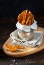 Baked potato wedges with addition sea salt and pepper on a black background, side view, close up Royalty Free Stock Photo