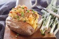 Baked potatoes with bacon, mushrooms and green onions in a rustic style on a wooden board. Royalty Free Stock Photo