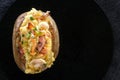 Baked potatoes with bacon and mushrooms in a rustic way on a wooden board. Close-up. Copy space. Royalty Free Stock Photo