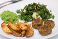 Baked potatoes, falafels, pea mousse and salad on white plate Royalty Free Stock Photo