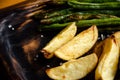 Baked potatoes and green beans are served on wooden platter. Eating at the restaurant. Vegetarian and vegan menu concept. Royalty Free Stock Photo