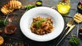 Baked potatoes with meat, mushrooms, onions and garlic on a plate. Royalty Free Stock Photo