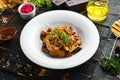 Baked potatoes with meat, mushrooms, onions and garlic on a plate. Royalty Free Stock Photo