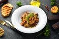 Baked potatoes with meat, mushrooms, onions and garlic on a plate. Royalty Free Stock Photo