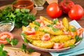 Baked potatoes in a peel with tomatoes in a plate Royalty Free Stock Photo