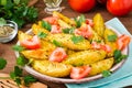 Baked potatoes in a peel with tomatoes in a plate and herbs Royalty Free Stock Photo