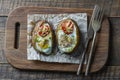 Baked potatoes stuffed with cheese, tomato, green onion and eggs on wooden background, top view, closeup Royalty Free Stock Photo
