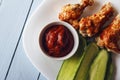 Baked poultry meat, tomato paste and sliced cucumbers on a white plate on a wooden table. Top view from above. Copy space for text Royalty Free Stock Photo