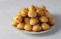 Baked profiteroles from puff pastry, choux pastry balls on a gray background
