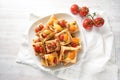 Baked puff pastry snacks with cream cheese, tomatoes and herb pesto, party finger food on a white plate, high angle view from Royalty Free Stock Photo