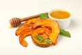 Baked pumpkin, mint, honey and dipper on white background