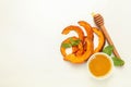 Baked pumpkin, mint, honey and dipper on white background