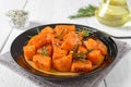 Baked pumpkin pieces with spices and herbs on white wooden background. Diet menu. Vegetarian dish Royalty Free Stock Photo