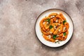 Baked pumpkin slices with herbs and cheese in a plate on a beige grunge background. Top view, flat lay Royalty Free Stock Photo