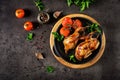 Baked quails in pan on a dark background. Top view.