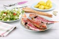 Baked red mullet served with boiled potatoes and green salad Royalty Free Stock Photo