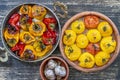 Baked red and yellow tomato and bell pepper. Tomatoes and bell peppers in a baking dish on a wooden table. A healthy and delicious Royalty Free Stock Photo