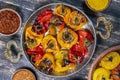 Baked red and yellow tomato and bell pepper. Tomatoes and bell peppers in a baking dish on a wooden table. A healthy and delicious Royalty Free Stock Photo