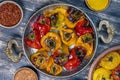 Baked red and yellow tomato and bell pepper. Tomatoes and bell peppers in a baking dish on a wooden table. A healthy and delicious Royalty Free Stock Photo