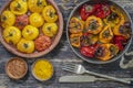 Baked red and yellow tomato and bell pepper. Tomatoes and bell peppers in a baking dish on a wooden table. A healthy and delicious Royalty Free Stock Photo