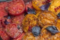 Baked red and yellow tomatoes with basil leaves