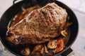 Baked roast beef with vegetables is in a frying pan. Top view