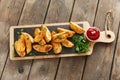 Baked roasted potato wedges with herbs and red sauce Royalty Free Stock Photo