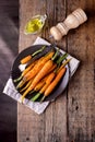 Baked Roasted Raw Freah Carrots with Olive Oil and Spices Lying on Plate Top View Horizontal Healthy Diet Organic Food Wooden