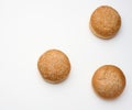 Baked round fresh white wheat flour bun sprinkled with sesame seeds on a white table. Hamburger, cheeseberger and sandwich bun Royalty Free Stock Photo