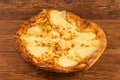 Baked round khachapuri on dish on the rustic table