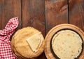 Baked round thin pancakes lie stacked on a wooden board, brown table