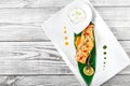 Baked salmon with cheese sauce, rosemary and lemon on wooden background. Hot fish dish. Royalty Free Stock Photo