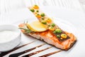 Baked salmon with cheese sauce, rosemary and lemon on wooden background close up. Royalty Free Stock Photo