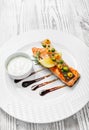 Baked salmon with cheese sauce, rosemary and lemon on wooden background close up. Royalty Free Stock Photo