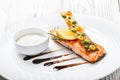 Baked salmon with cheese sauce, rosemary and lemon on wooden background close up. Royalty Free Stock Photo